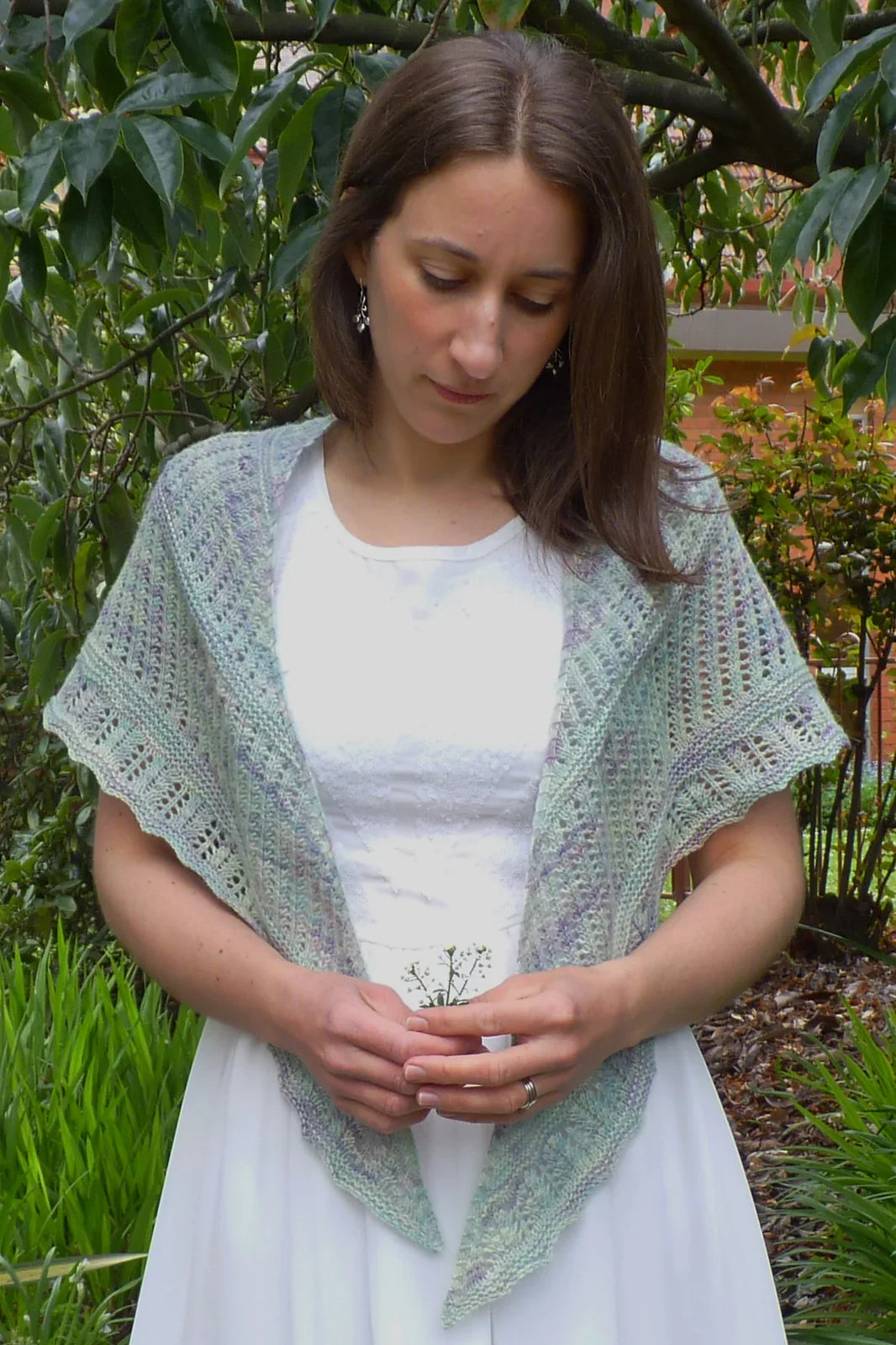 Woman in white dress wearing hand-dyed Mint Rainwater shawl outdoors among greenery