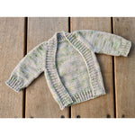 Baby frontless cardi in hand dyed yarn on a wooden background.
