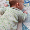 Close up of a baby from the back wearing a 'baby vertebrae' in hand dyed yarn.